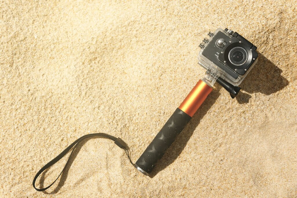 action cam with sticks lying in sand