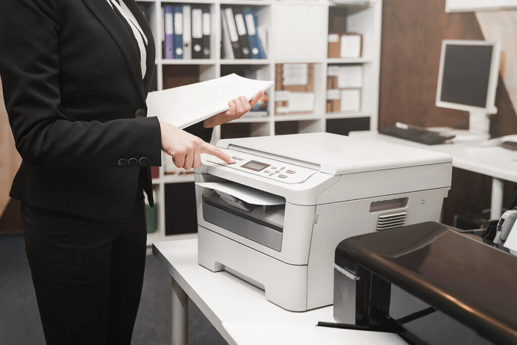 Woman in blazer uses multifunction printer in office