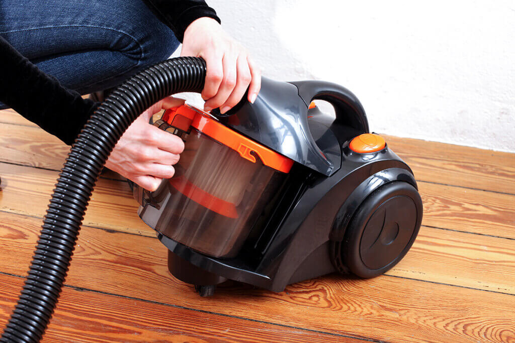 bagless vacuum cleaner woman empties container out