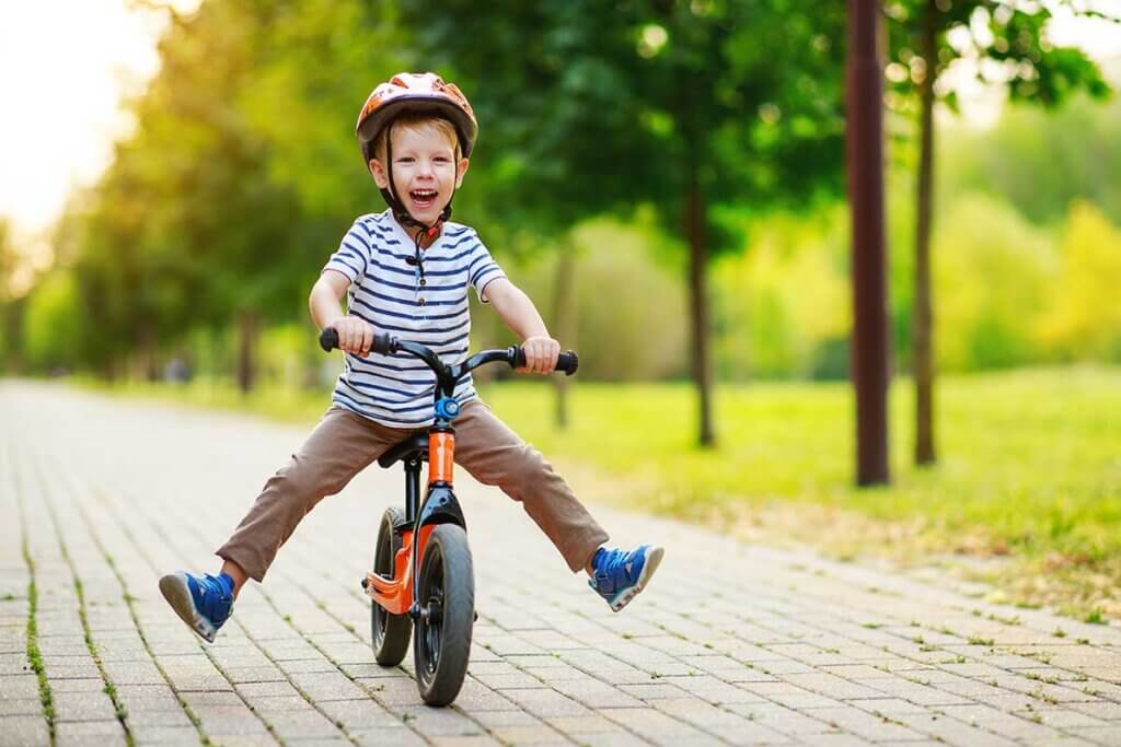 boy rides on balance-bike through bike