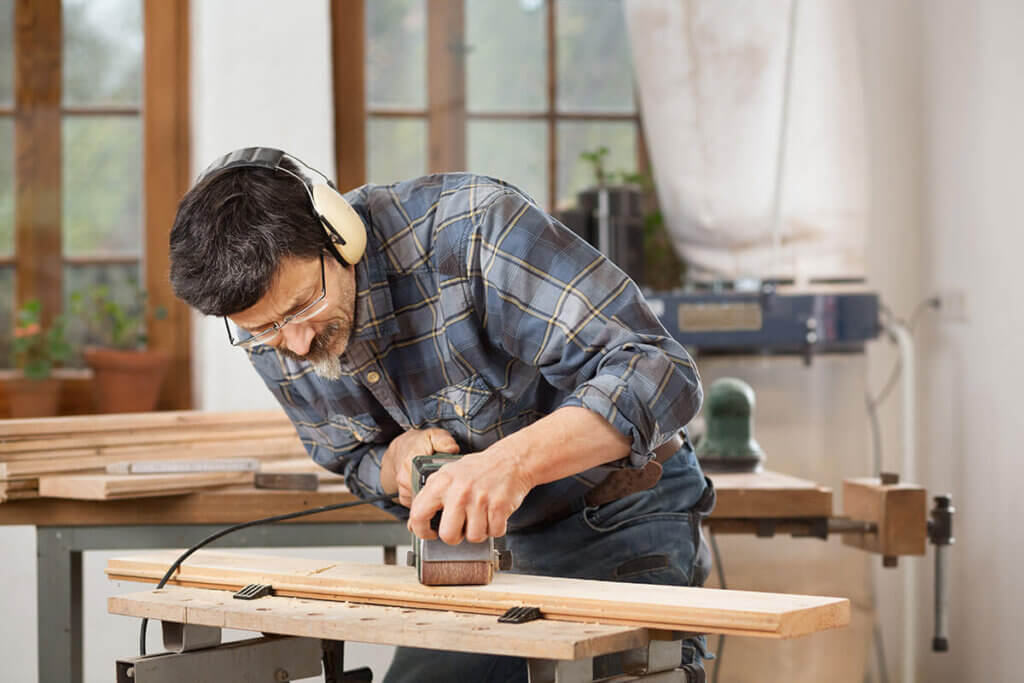 Person sanding wooden board