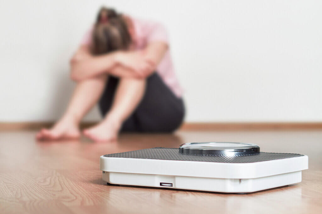 body fat scale woman desperately in front of scale