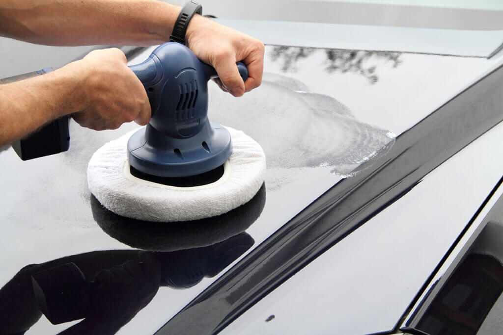 Person polishing car with polishing machine