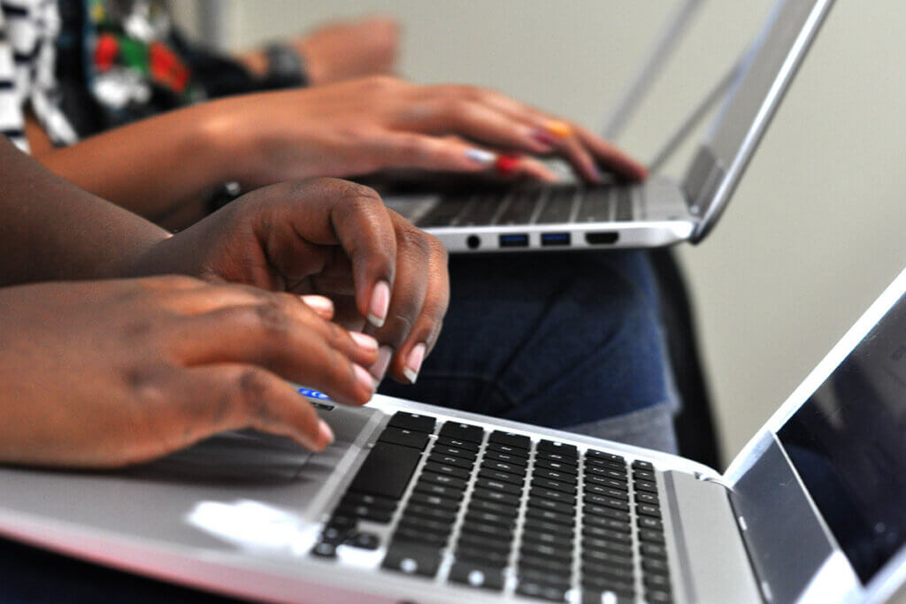 people sitting next to each other and working with their chromebook