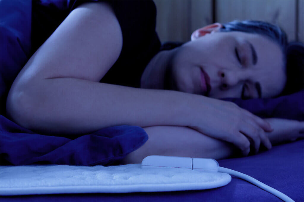 Woman sleeping on electric blanket