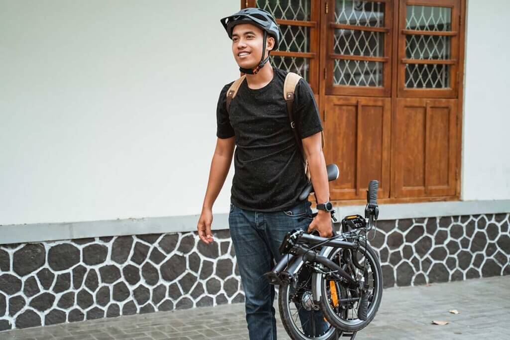 man carrying folded bike
