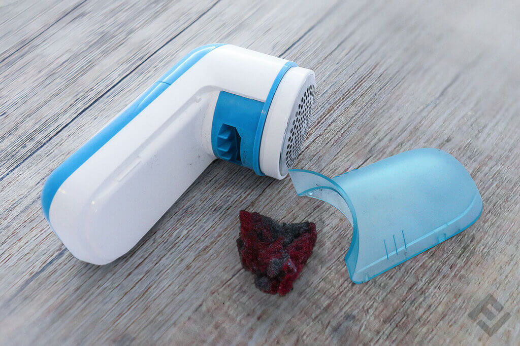 Philips fabric shaver with open pill container and a pile of lint