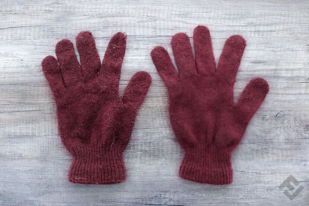 Two red woolen gloves on a table