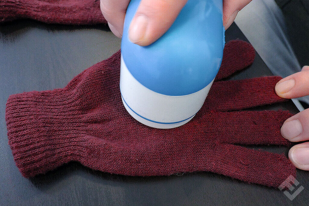 Philips fabric shaver used on a red woolen glove