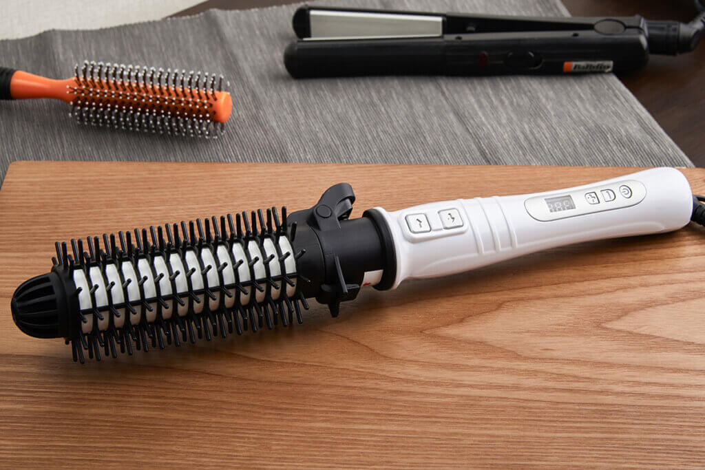 Brush and straightener on a wooden table