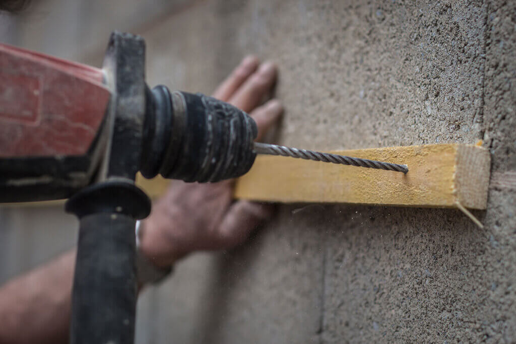 Drilling through wood with a percussion drill