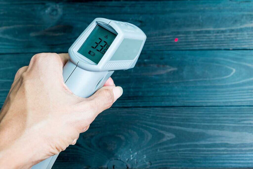infrared thermometer is held against the wall