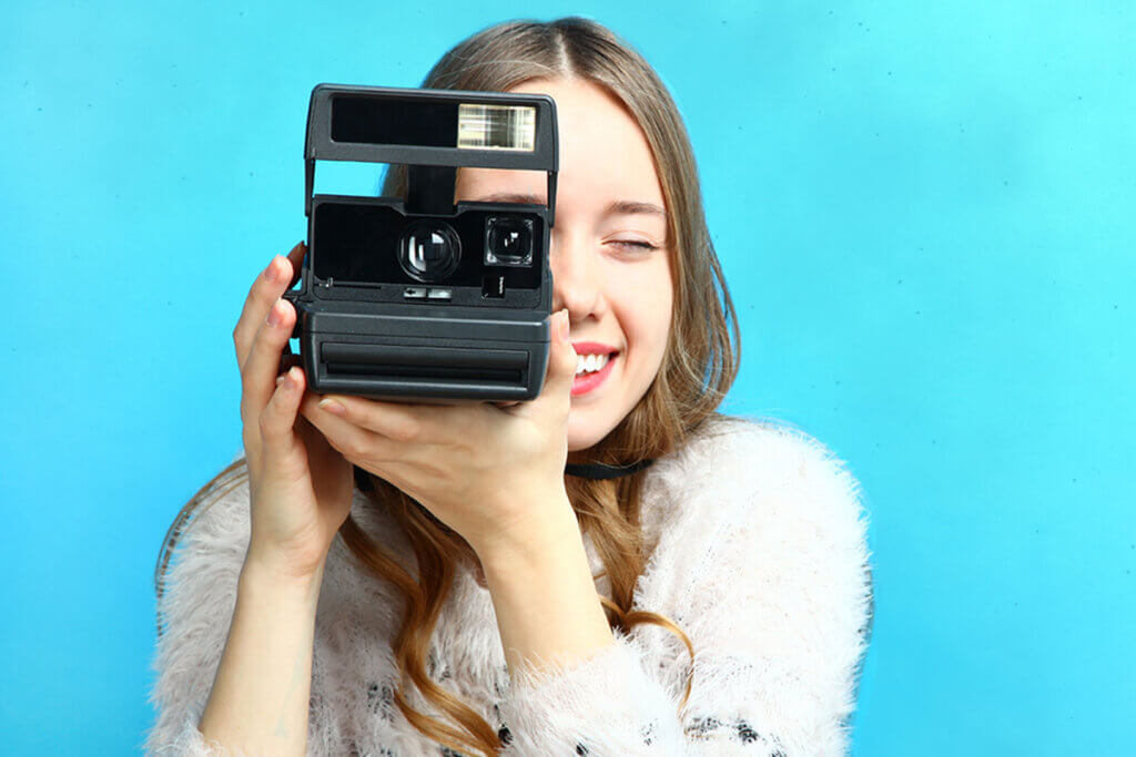 woman takes photo with an instant camera