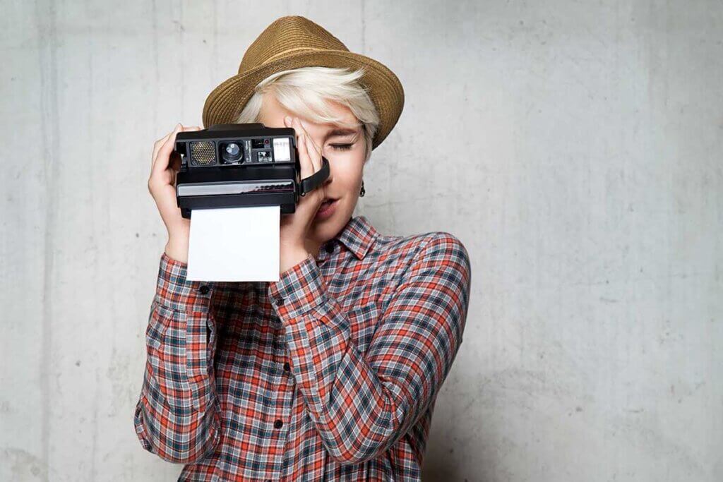 woman takes photo with an instant camera