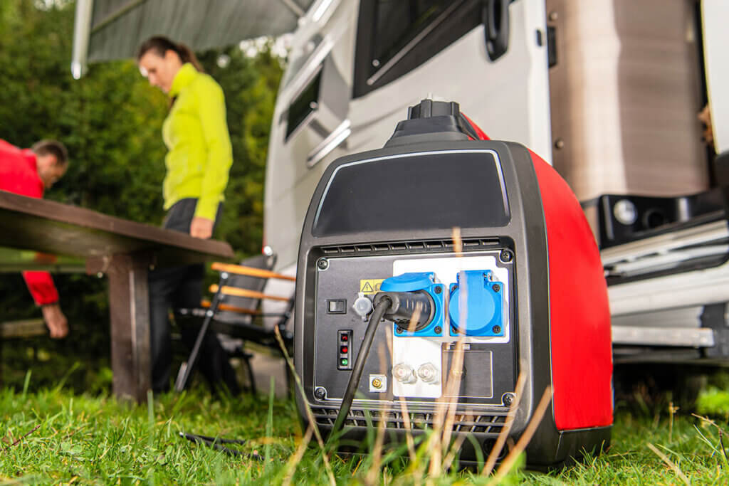 Man operates inverter power generator in front of motorhome