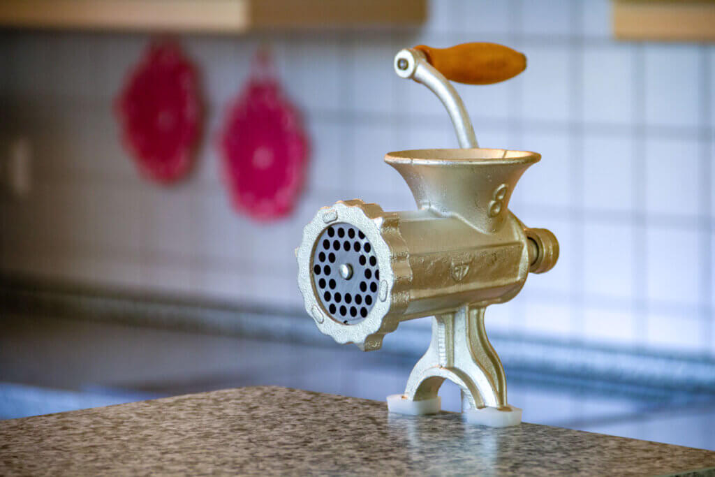  Meat grinder with wooden handle on the table