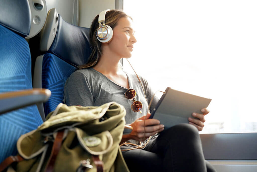 young woman sitting on the train listening to music
