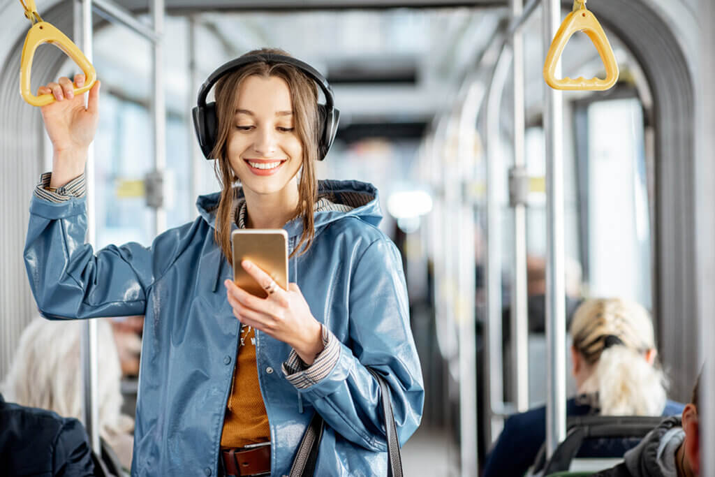 Young woman on train with headphones on head