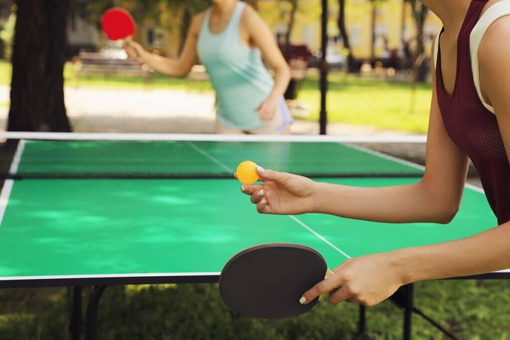 two women play together table tennis