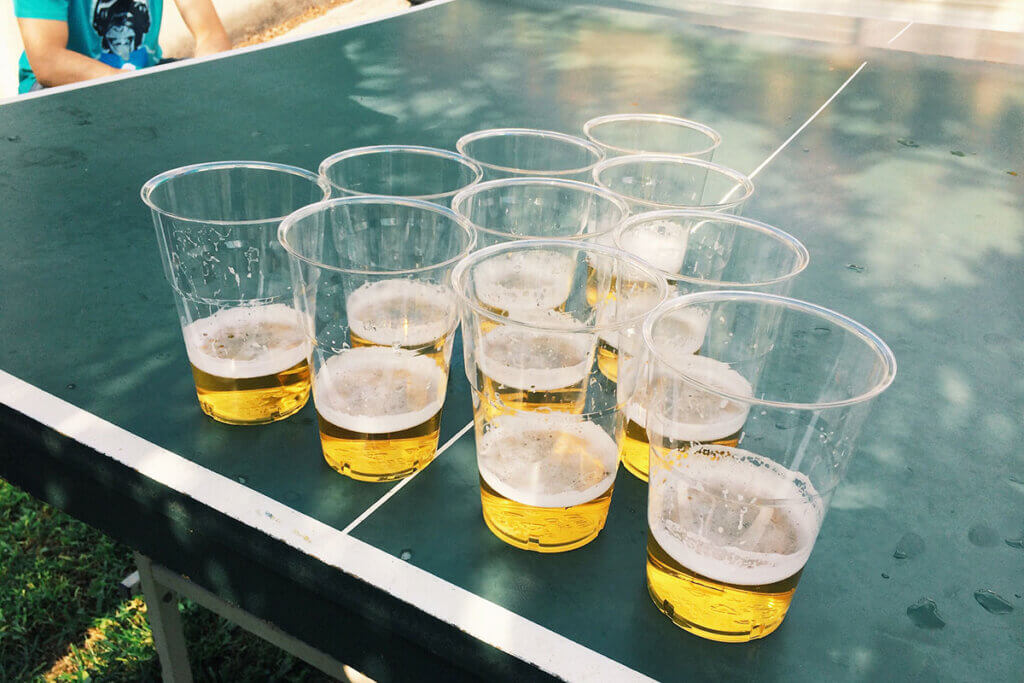 Beer pong table set up outside with beer