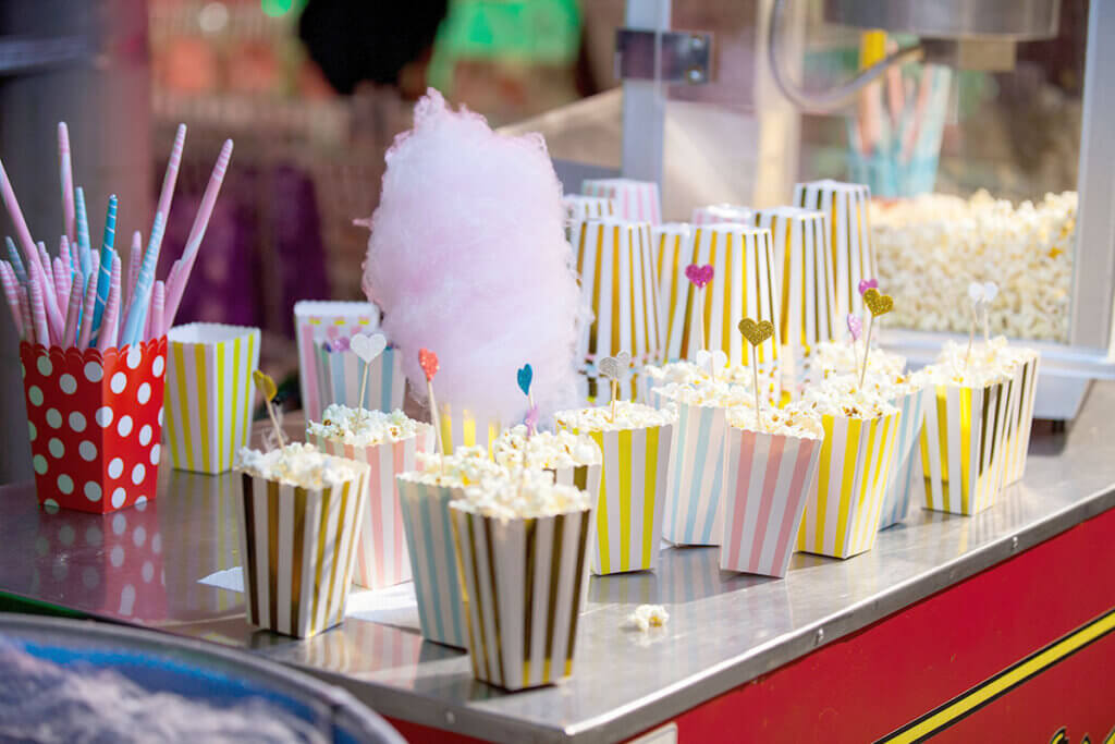 Large popcorn machine with popcorn bags and candyfloss