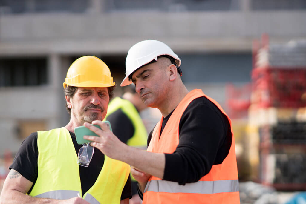 Construction worker using smartphone on building site