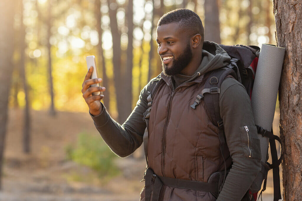 Man in forest looking at smartphone