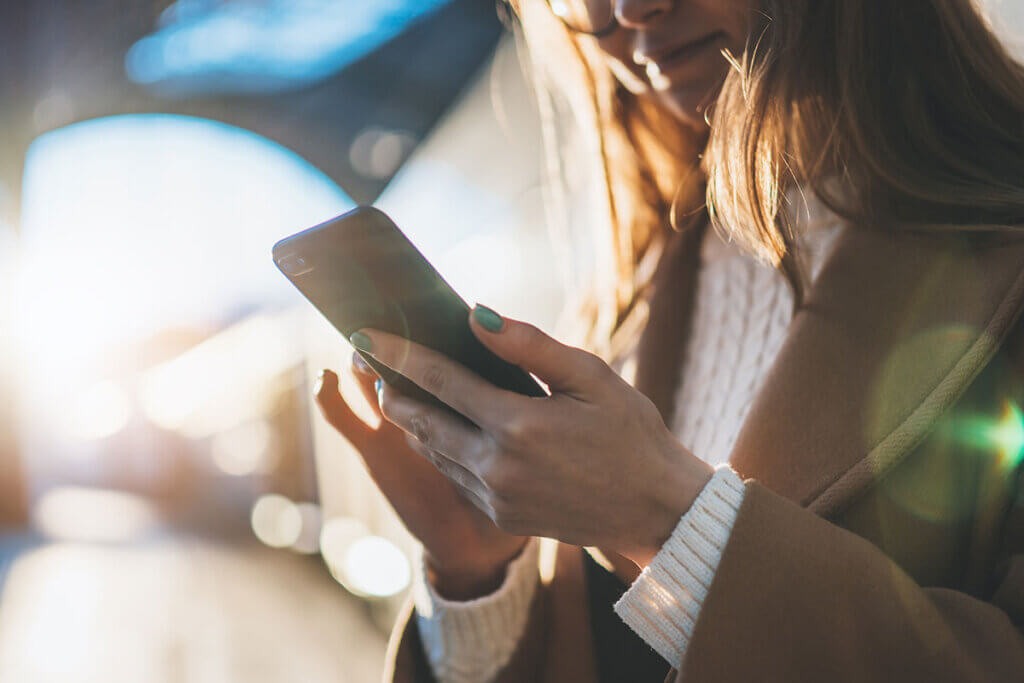 Woman holding smartphone at train station