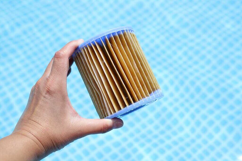 man keeps cartridge filters above the pool