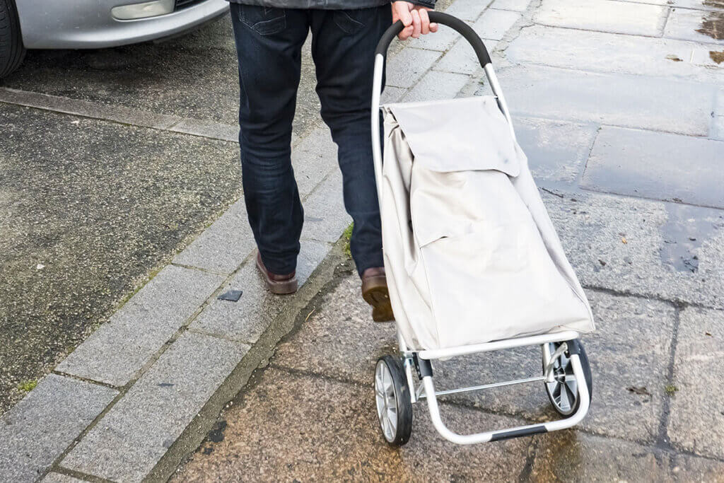 White trolleys with large wheels are pulled along the pavement