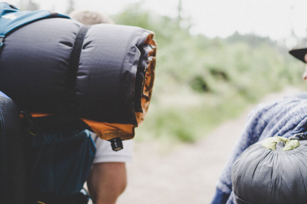 Inflatable sleeping mat attached to a backpack.