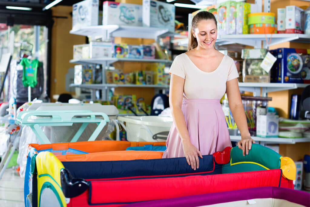 Pregnant person chooses a travel cot in the shop