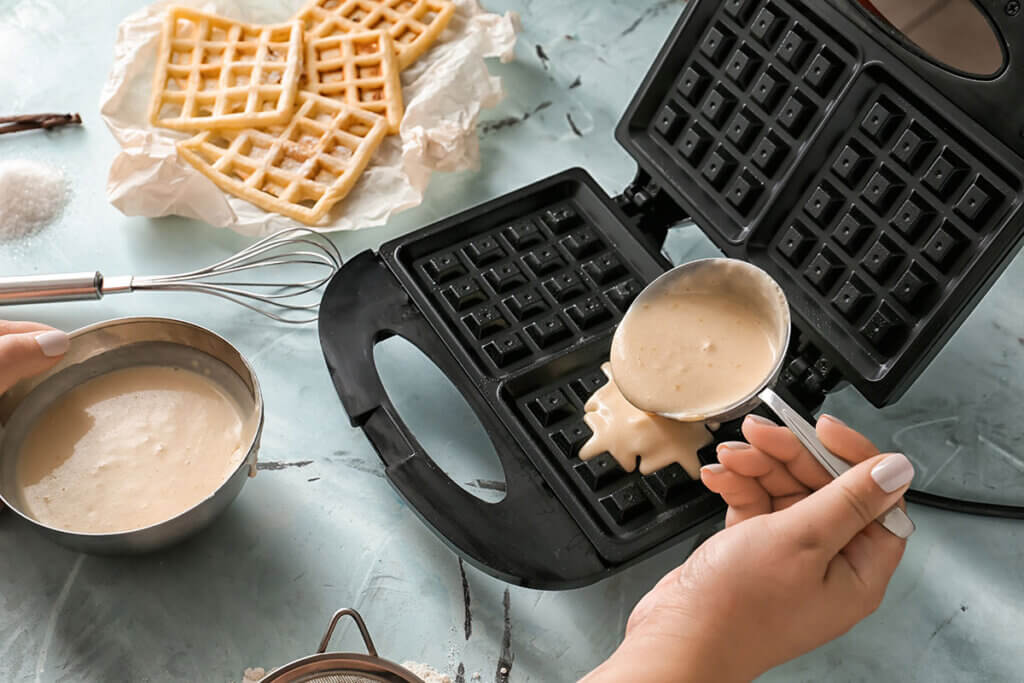 woman_pours_batter_into_waffle_maker