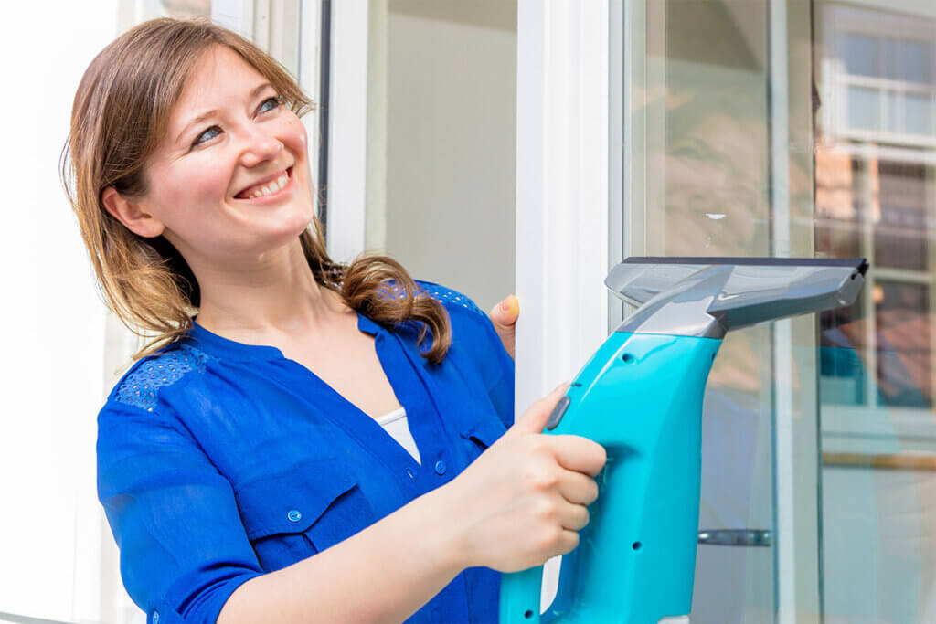 Woman uses window vacuum cleaner