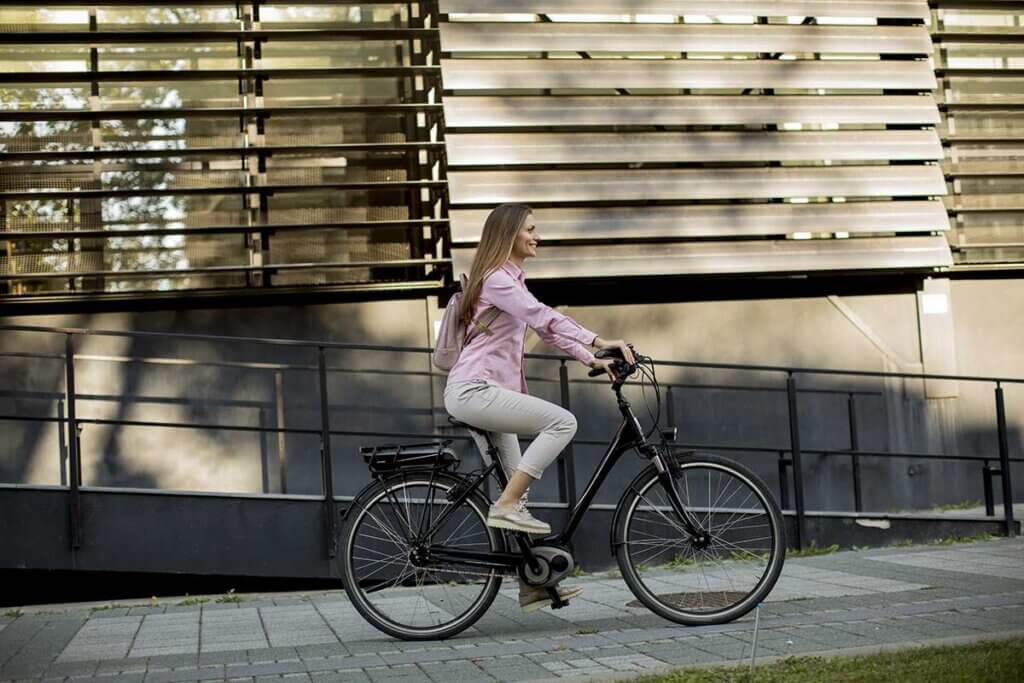 young_woman_riding_e_bike_through_city