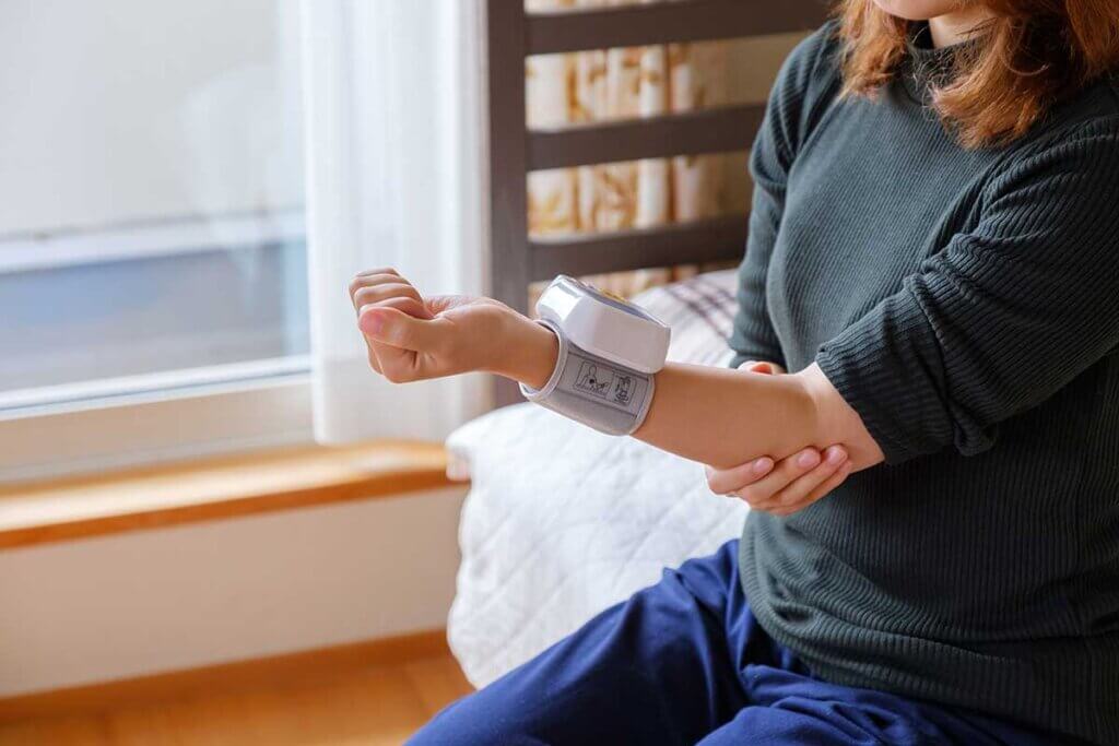 woman with wrist blood pressure monitor